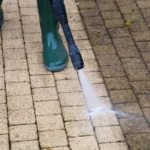 Pressure washing dirty pavers to remove stains and buildup